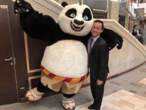 Jono stands next to a large panda costume.