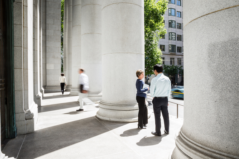 people in shadow of columns