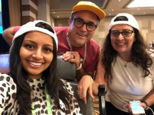 Nish and two of her peers all wearing hats and smiling for the camera.