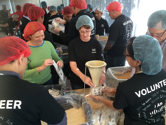 Cisco employee volunteers sort and package food at an event with Stop Hunger Now