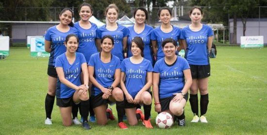 Alejandra and her teammates in Cisco jerseys on a soccer field.