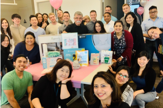 Pat and her team smiling around Ali at his grandbabby shower.