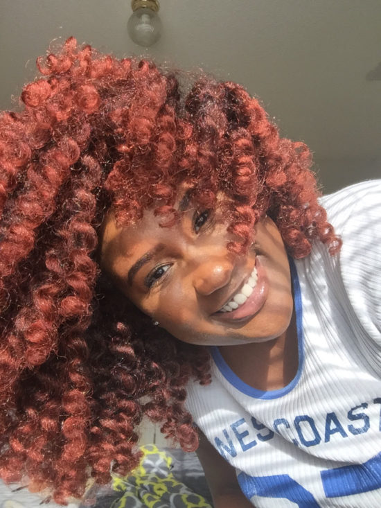 Leigh smiles as she proudly shows off her colorful red hair.