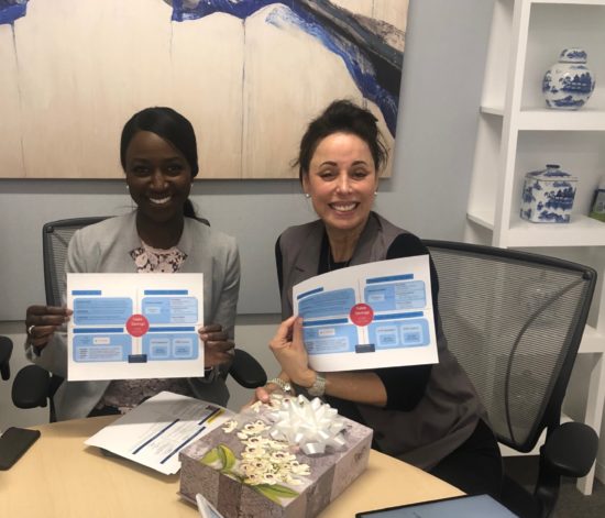 Cisco head of sales Gerri Elliott and a colleague smiling with Ron's very important message and the colorful box it came in!