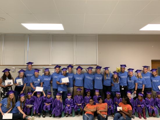 A large group of CSAP students and their adopted classroom graduating.