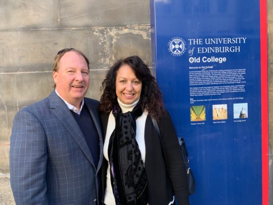 Ed smiling next to a sign that reads The University of Edinburgh Old College.