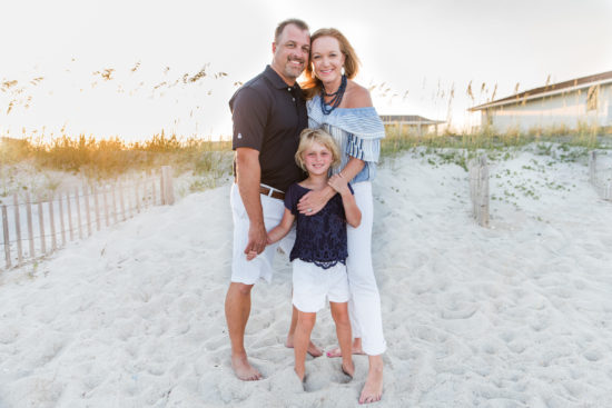 Erin holds her husband and daughter close on a beach in North Carolina.