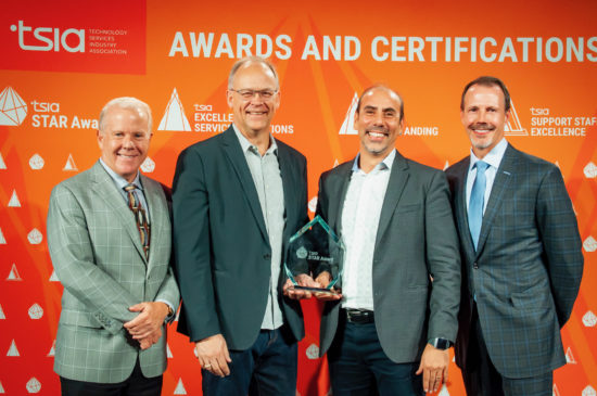 Emilio's CX Portfolio Project team smiling while holding their Technology Services Industry Association award.