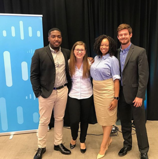 Chloe smiles with colleagues in front of a Cisco backdrop.