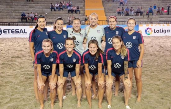 Jeane smiles with her teammates, the U.S. Women’s Beach Soccer National Team.