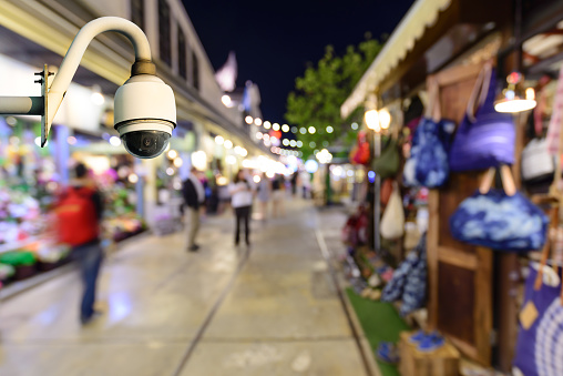 Security camera monitoring events in shopping center at night.