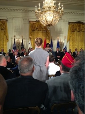 Courtney Beard stands as First Lady Michelle Obama acknowledges her years of military service. 