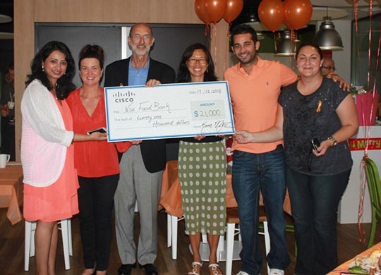 Cisco employees in Australia present a check for US$21,000 to the New South Wales Food Bank. 