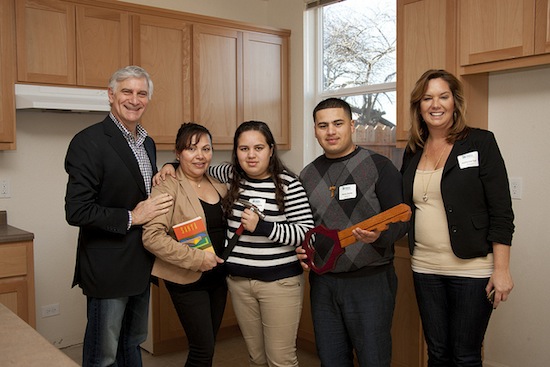 Cisco employees Steve Martino (left) and Katherine Toch (right) with the Zavala family in their new home.