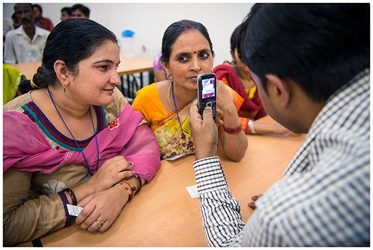 Trainers at a garment factory in India show workers how to use mobile phones to take anonymous surveys. Photo: Arjun Kartha